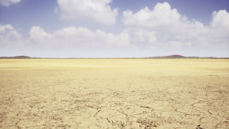 vast arid landscape with cracked ground under a bright blue sky