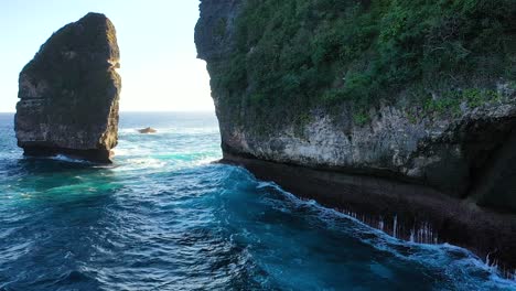 Vista-Aérea-De-Las-Olas-Del-Océano-Turquesa-Rompiendo-Los-Acantilados-De-La-Isla-De-Nusa-Penida,-Una-De-Las-Atracciones-Turísticas-De-La-Isla-De-Bali-Playa-De-Cristal-Playa-De-Kelingking-ángulo-Playa-Rota-De-Billabong