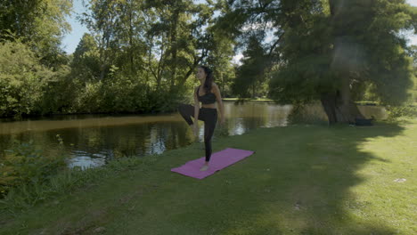 Mujer-Joven-Haciendo-Pose-De-árbol-En-Un-Hermoso-Parque-Verde