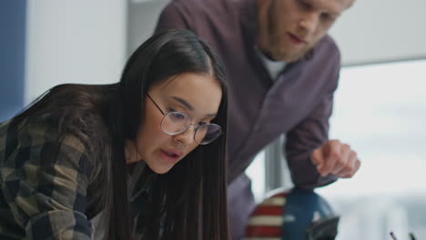 equipo de primer plano trabajando juntos en un lugar de trabajo panorámico. mujer dibujando un plano