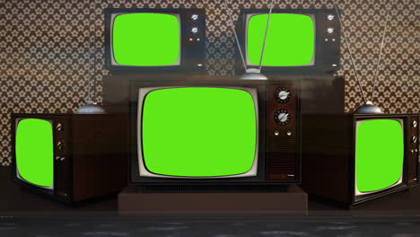 An-exhibition-of-old-fashioned-retro-color-tv-sets-with-antennas.-Electronic-devices-stack-in-front-of-vintage-wallpaper.-Obsolete-television-is-displaying-a-green-screen.