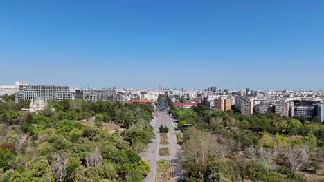 drone perspective of tineretului park entrance, bucharest's cityscape and traffic in the background, romania