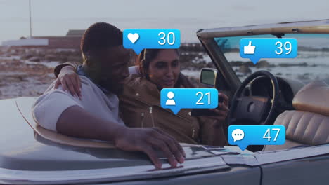 engaging with social media notifications, couple in convertible by beach