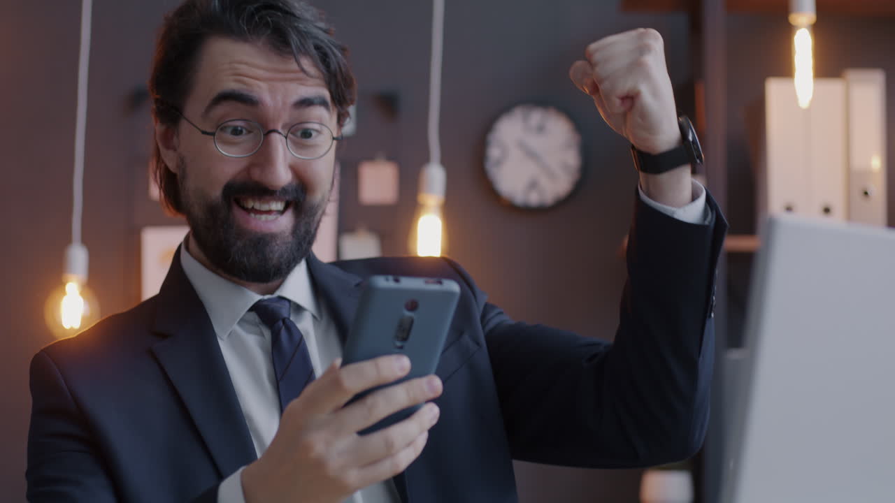Happy Businessman Celebrating Success on Smartphone
