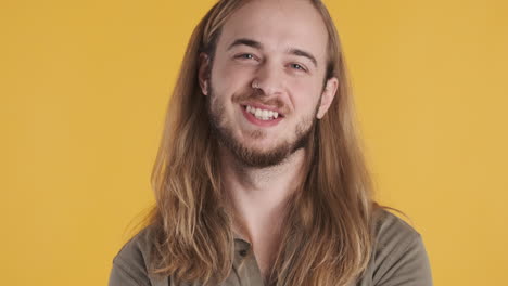 un joven caucásico sonriendo a la cámara.