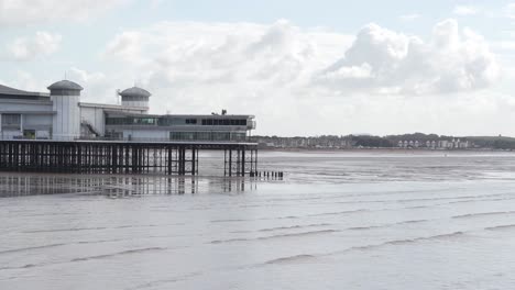 Letzter-Abschnitt-Des-Grand-Pier-Weston-super-mare-Mit-Einem-Bewölkten-Und-Blauen-Himmel-Im-Hintergrund,-Sanfte-Wellen,-Die-Am-Strand-Brechen