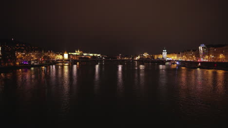 Puente-De-Charles-Y-Río-Vltava-En-La-Ciudad-De-Praga-Nocturna-Iluminada-Por-Luces