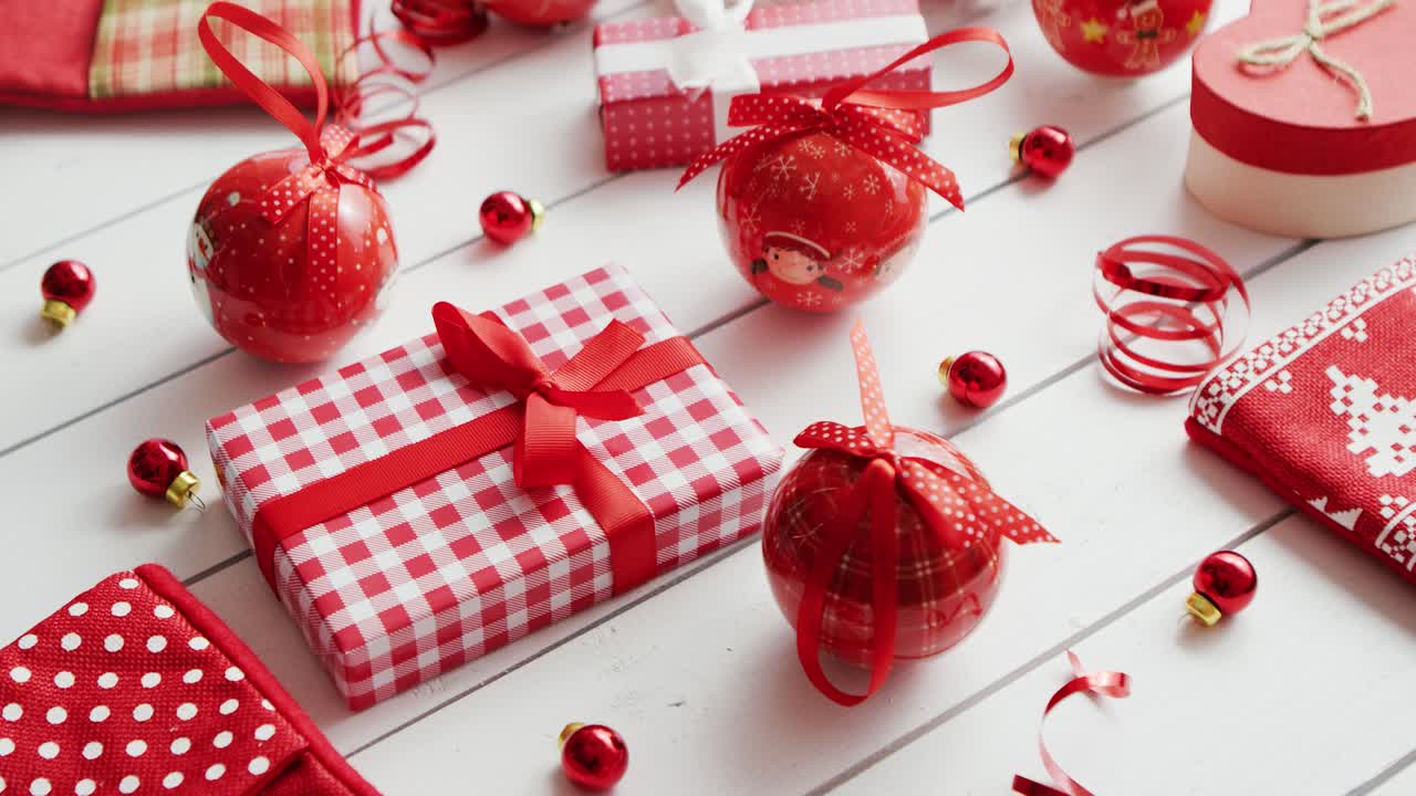 Christbaumkugeln und Perlen neben Weihnachtsgeschenken