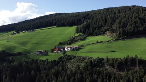 traditional alpine houses on grass hills in italian dolomites, val di funes