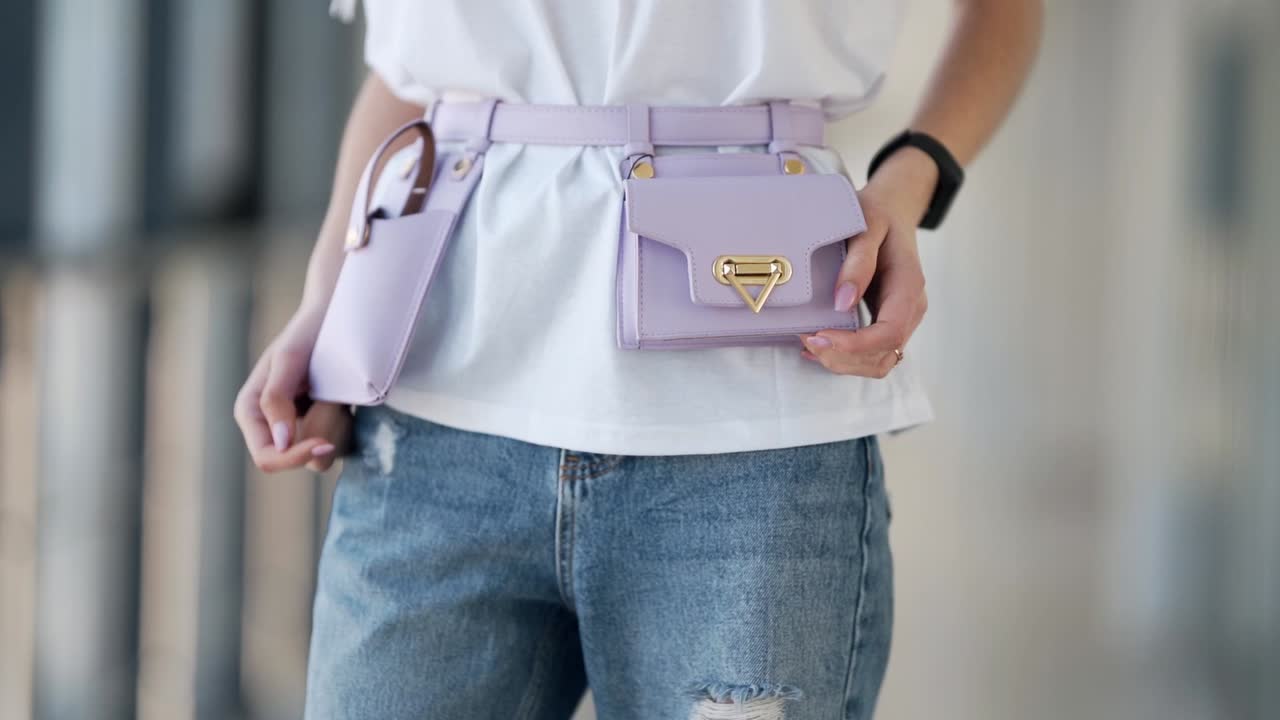 primo piano di un micromuschio viola lungo fino alla vita su una ragazza in jeans e camicetta bianca
