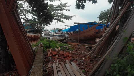 Flying-through-boat-construction-at-Belitung-island-Indonesia,-aerial