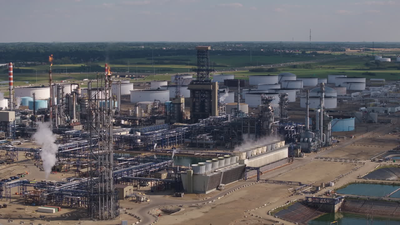 Industrial refinery landscape with smoke stacks under a clear sky