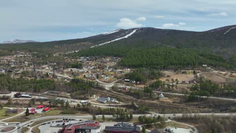 Dombaas-Norway-during-spring---High-angle-aerial-above-road-looking-towards-intersection-to-Dovrefjell