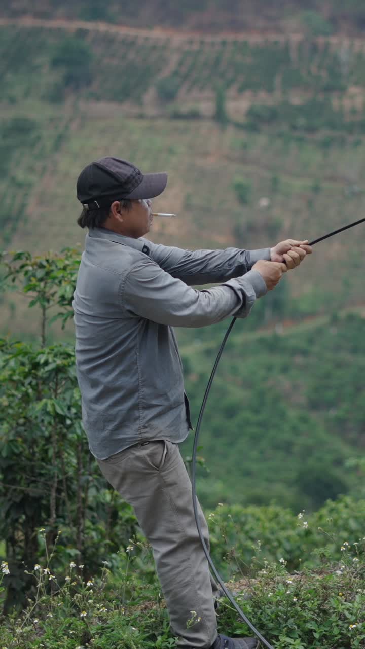 Man holding a cable in a landscape