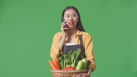 woman farmer talking on phone with vegetables