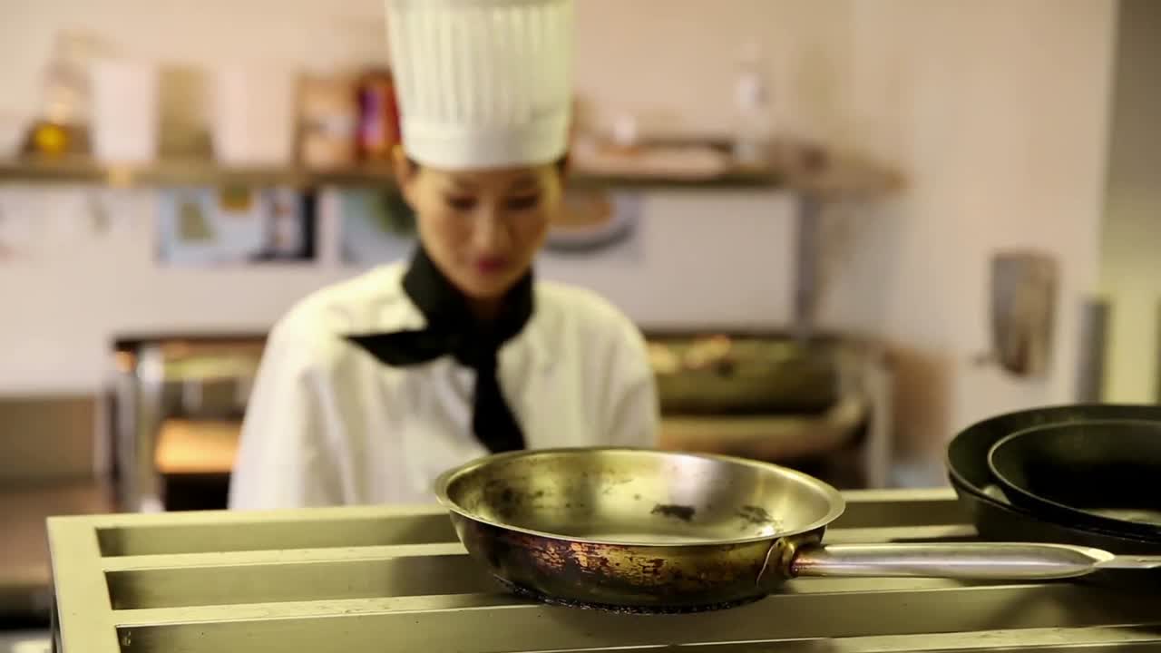 Chef felice che prende pentole e padelle da uno scaffale