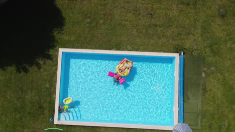 la gente se relaja en las piscinas inflables bajo el sol de verano, vistas desde arriba