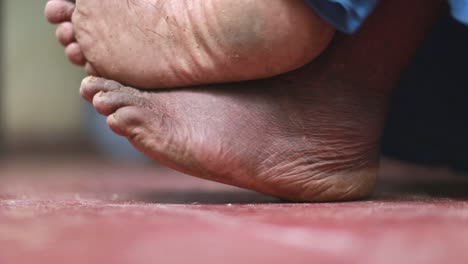 man's feet sitting cross legged and resting on a concrete floor