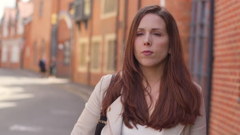 Woman-Outdoors-Walking-To-Work-Along-City-Street-Lined-With-Houses