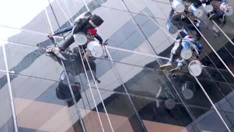 trabajadores en cuerdas que fijan ventanas de gran altura