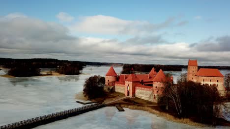 Trakai-Castte-Lithuania,-drone-shot-of-the-medieval-castle-in-a-frozen-lake-on-a-cloudy-day