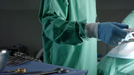 diverse surgeons with face masks using surgery tools in operating room in slow motion