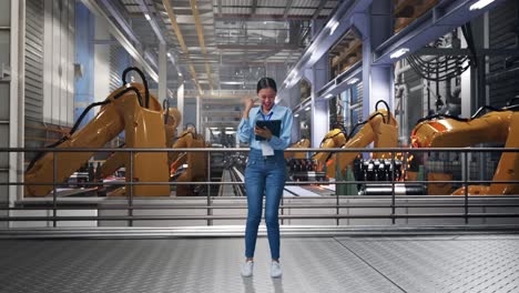 full body of asian female with her tablet with industrial robotic arms working, she raises her fist up with screaming goal after typed on the tablet