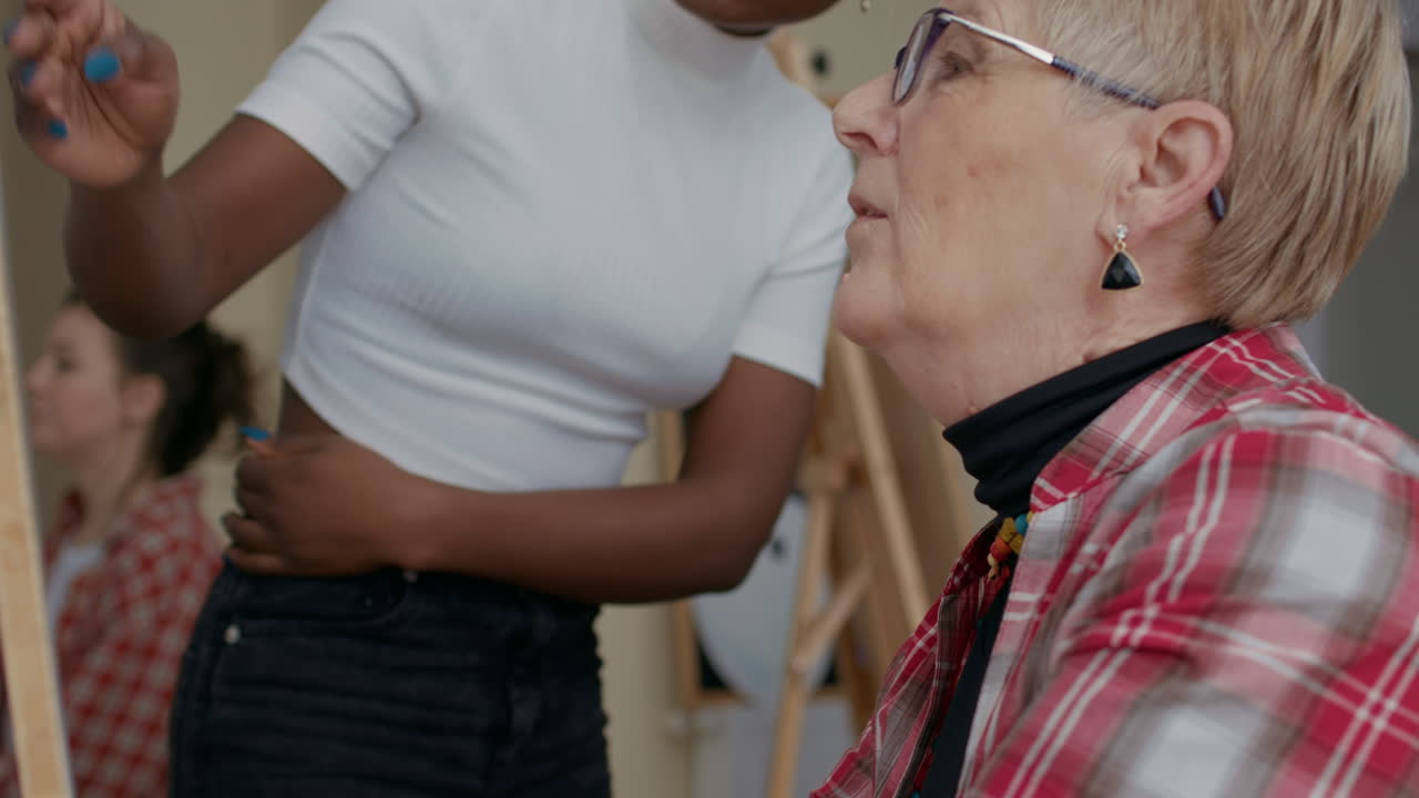 Art class teacher guiding senior student to draw sketch