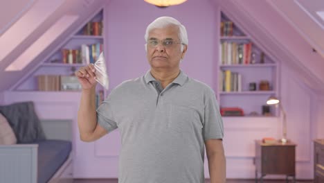 Confident-Indian-old-man-using-money-as-fan