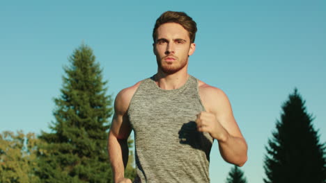 Sport-man-running-in-park-on-blue-sky-background.-Male-runner-run-in-park