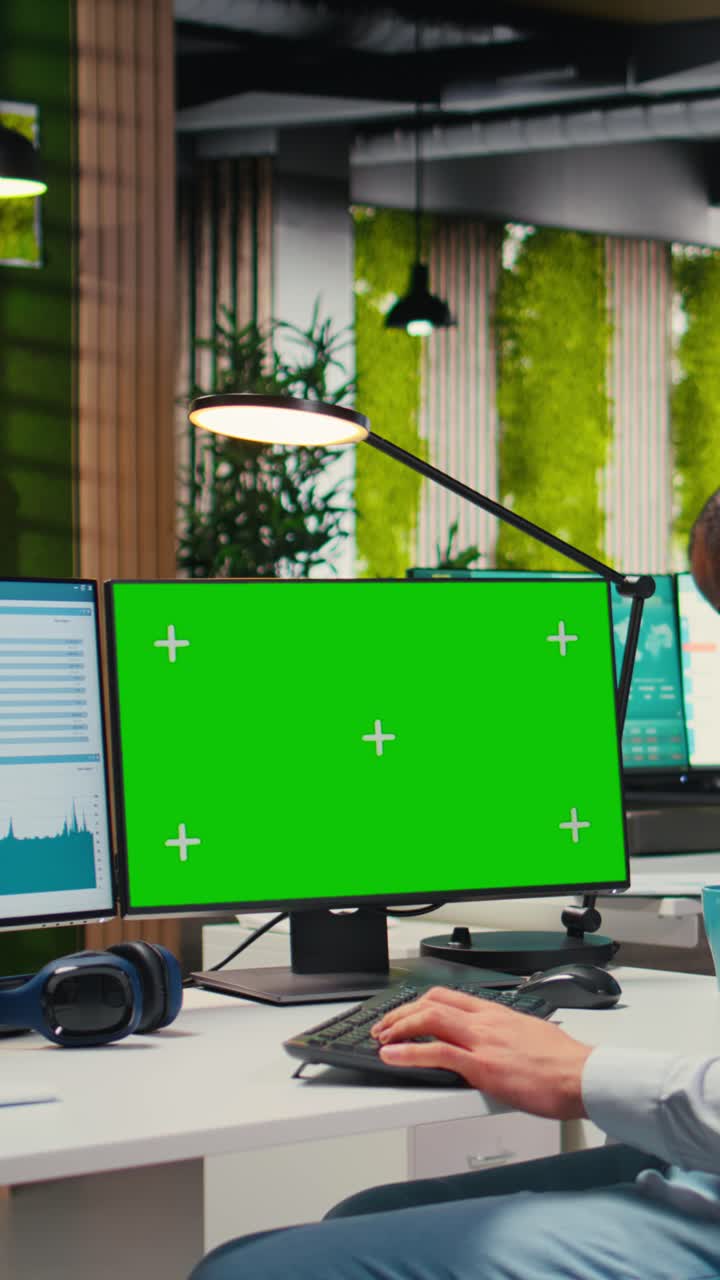 Vertical Video Employee engaged in business planning with a green screen in the office