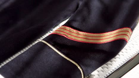 slow rotating shot of a military man's outfit with golden stripes on the arm