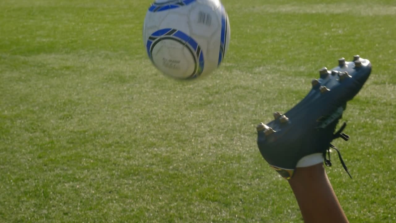 Spillere træner fodbold på banen 4K
