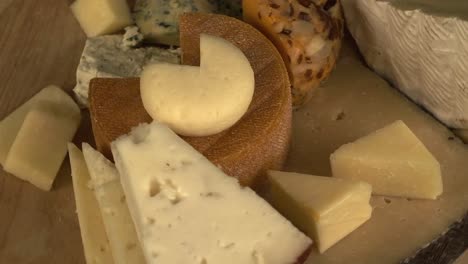 high angle view of wooden cheese platter rotating, close up