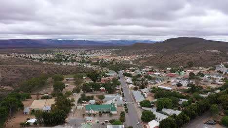 Vista-Aérea-De-Una-Ciudad-Remota-En-Sudáfrica-Paisaje-De-Montañas-De-Día-Nublado