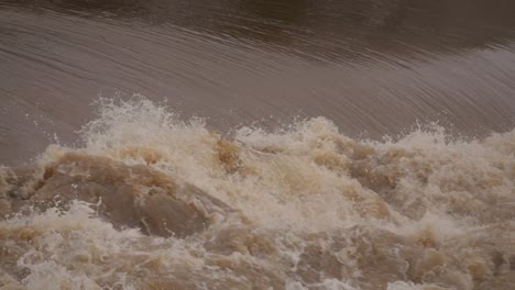 coomera, gold coast, 2 january 2024 - rough fast flowing water across the coomera river causeway under flood waters from the 2024 storms in january