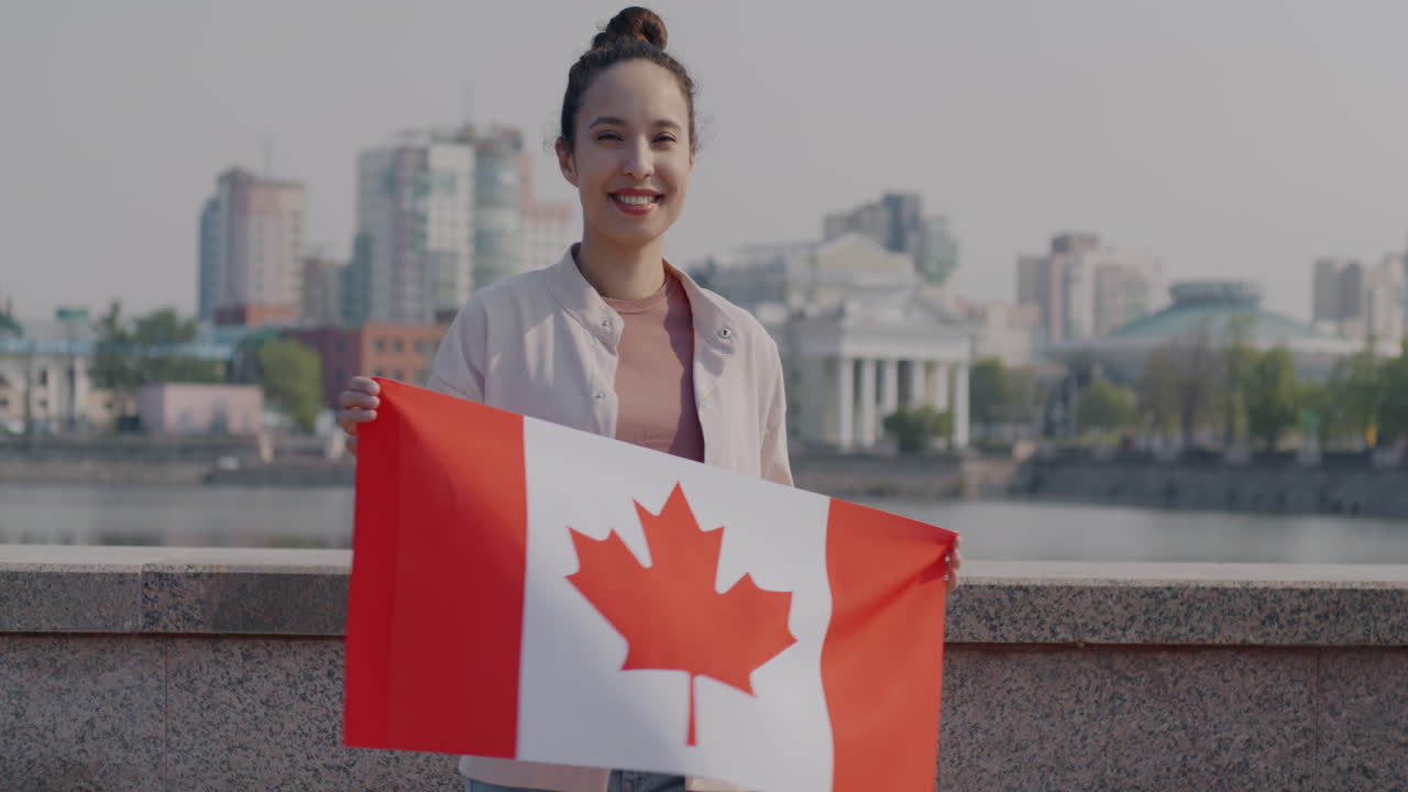 Mujer sosteniendo la bandera canadiense en una ciudad