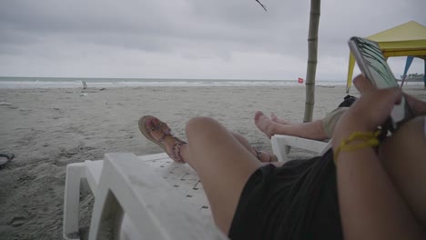 mujer relajándose en la tumbona y viendo nubes de tormenta sobre el océano, playa ecuador