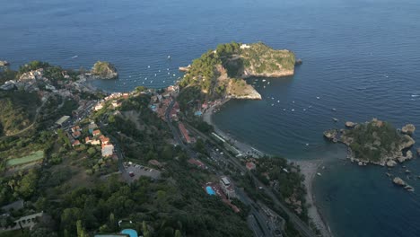 4k aerial of isola bella at sunset, in taormina, sicily in july 2025