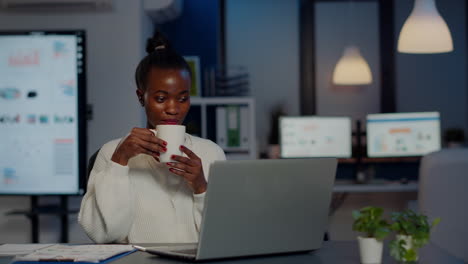 Schwarze-Geschäftsfrau,-Die-Während-Einer-Videokonferenz-Kopfhörer-Benutzt-Und-Kaffee-Trinkt