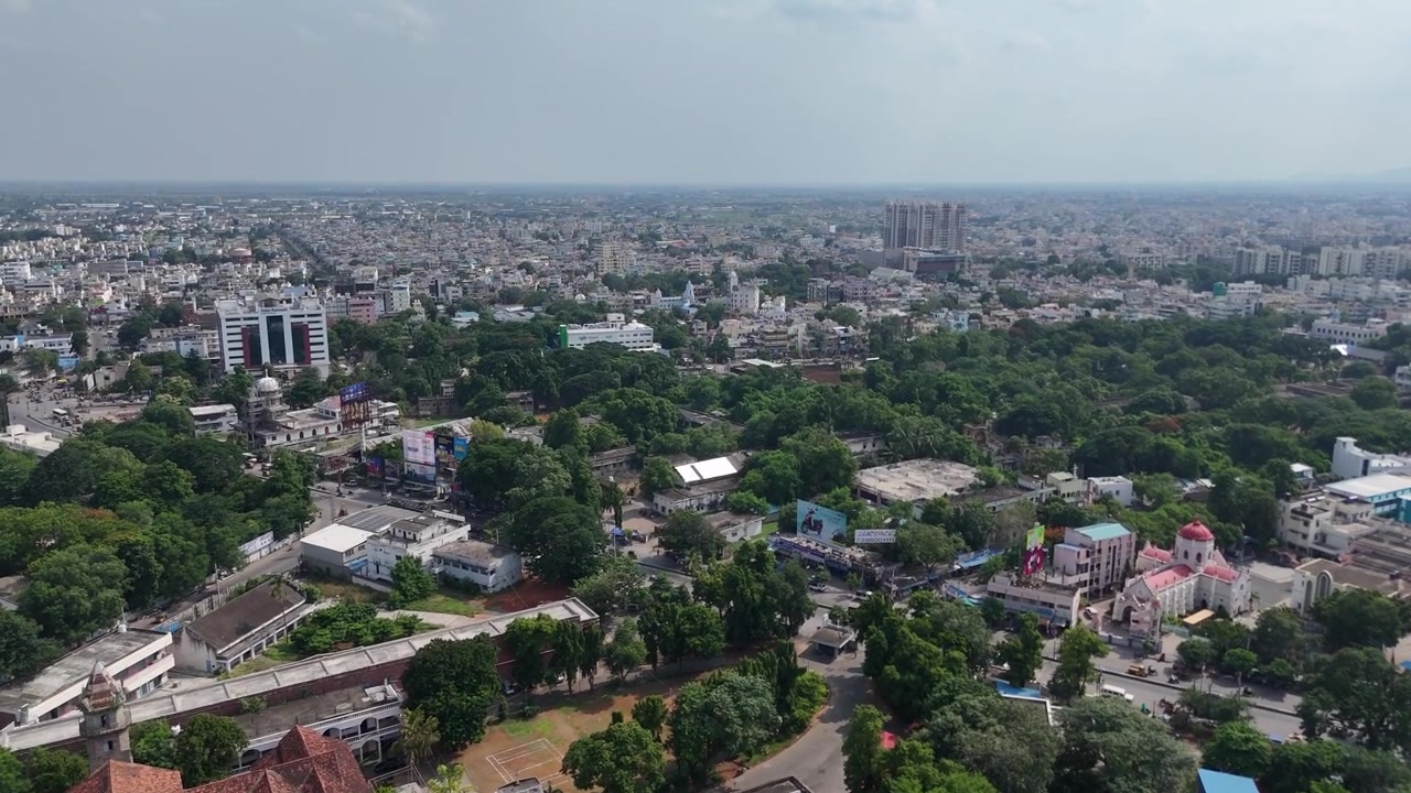 Un'ampia veduta aerea della città di Vijayawada, che mostra l'integrazione delle strutture urbane con la collina naturale sullo sfondo.