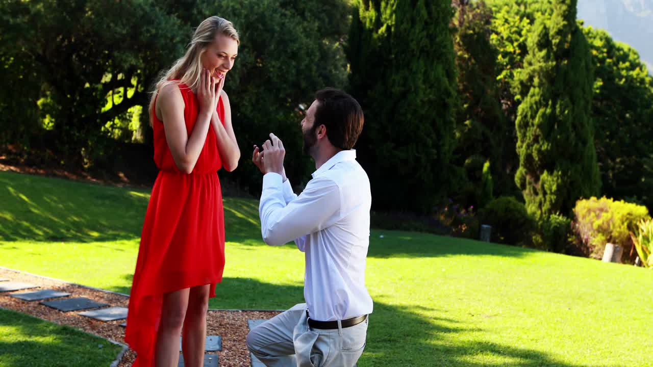 Man proposing a woman with a ring on his knee 4k