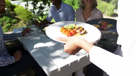 Waitress-serving-breakfast-to-group-of-friends