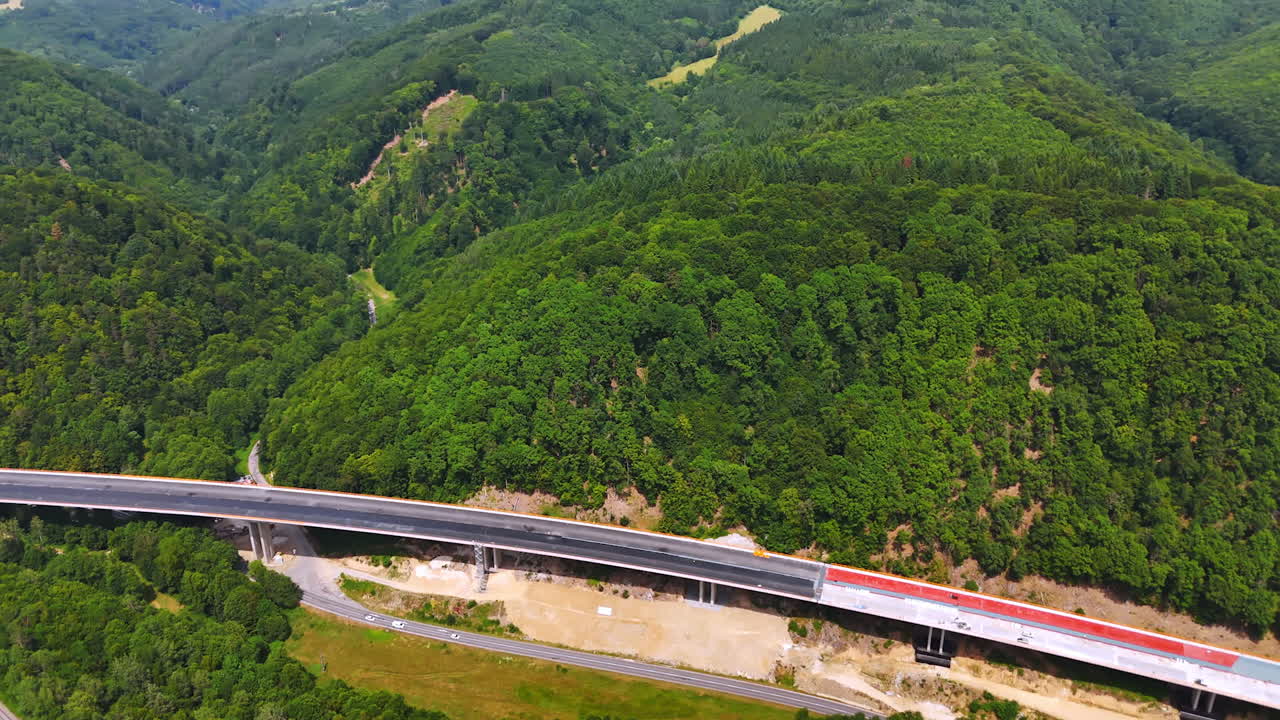Highway curves through lush green hills. A highway winds through dense green forests, showcasing nature's beauty and infrastructure in harmony during daytime