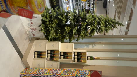 Christmas-shopping-mall-decorations,-tree-and-champagnes-vertical,-dolly-in