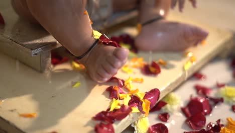un baño de bebé de 1 año con leche una mezcla de chandan haldi flores baño real de los padres y las piernas de los abuelos