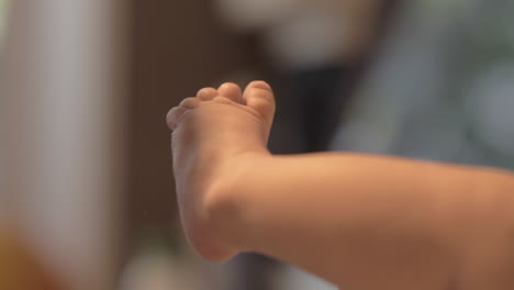 mother expressing love for newborn baby with kissing small feet