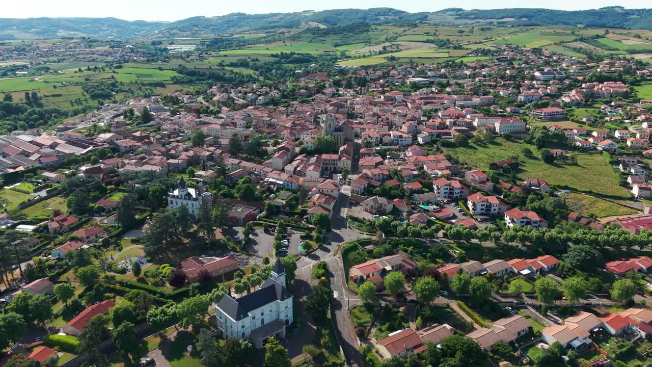 aerial shot above saint martin la plaine near saint etienne, revealing the monts du lyonnais in the background on a sunny day, loire departement, auvergne rhone alpes region, france