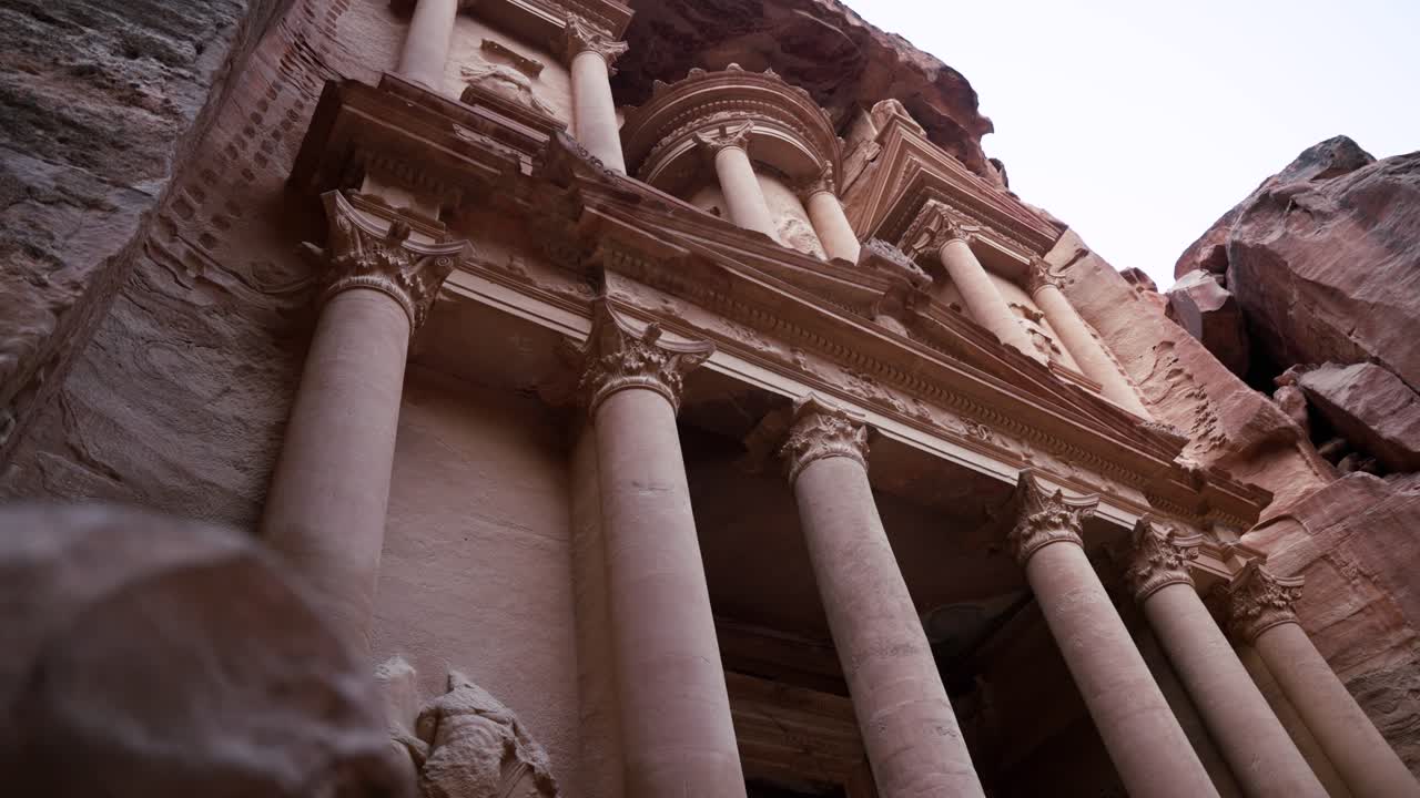 Low-angle view of Petra’s Treasury, Al-Khazneh, iconic rose-red facade, Jordan.