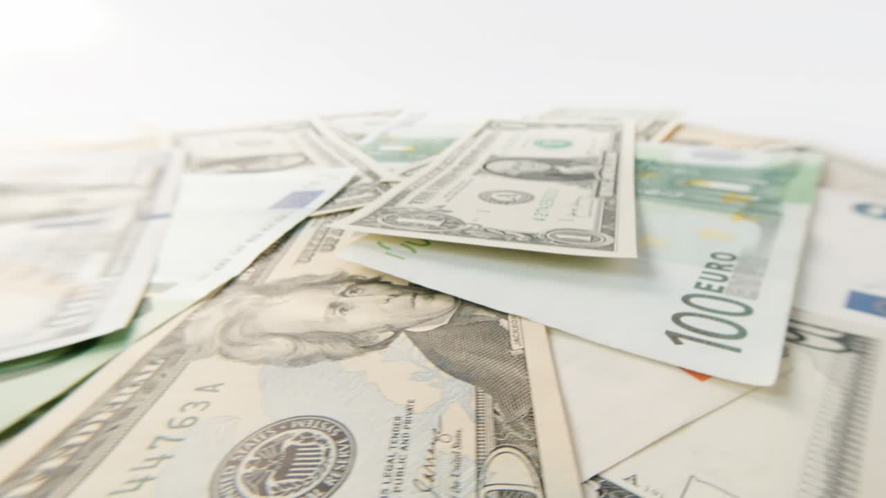 Rotating banknotes of dollars and euros of various denominations close-up. Background of rotating dollars and euros. 4k macro raw video.